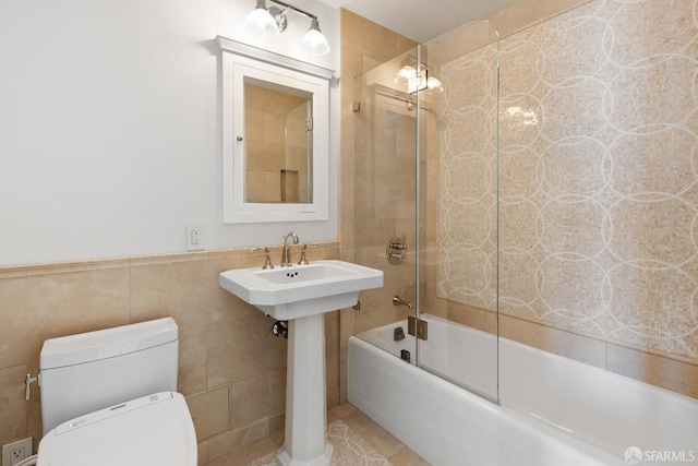 bathroom with tile patterned flooring, enclosed tub / shower combo, tile walls, and toilet