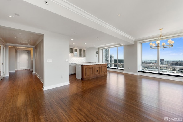 unfurnished living room with a chandelier, dark hardwood / wood-style floors, and ornamental molding