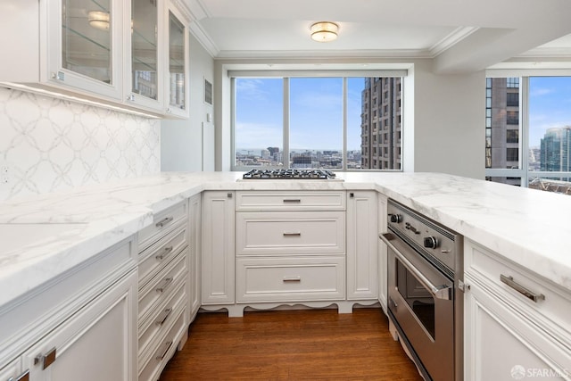 kitchen featuring decorative backsplash, white cabinets, a healthy amount of sunlight, and appliances with stainless steel finishes