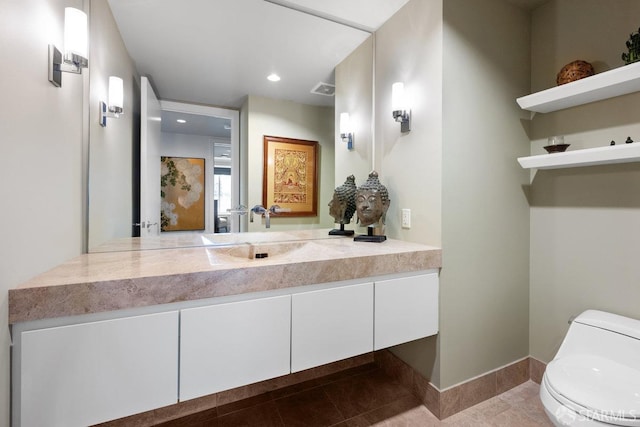 bathroom with vanity, toilet, and tile patterned floors