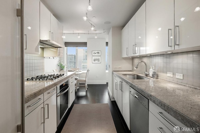 kitchen featuring white cabinets, sink, stainless steel appliances, dark hardwood / wood-style floors, and decorative backsplash