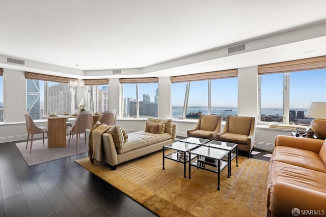 living room featuring a wealth of natural light, a water view, and hardwood / wood-style flooring