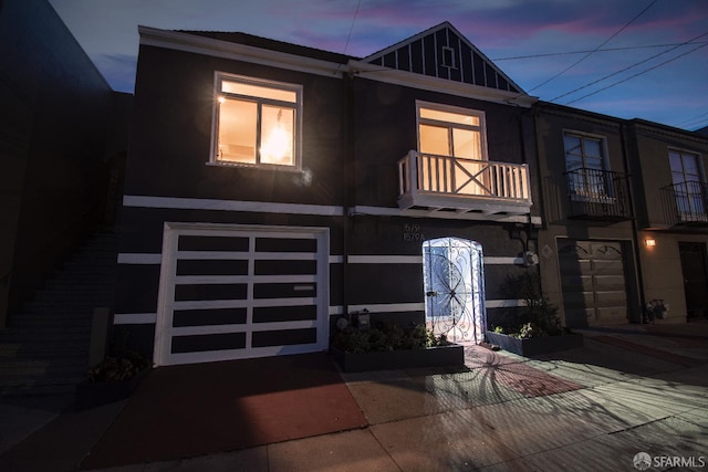 1579 46th Ave, San Francisco, CA 94122 - view of front facade with a garage, a balcony, stucco siding, and driveway