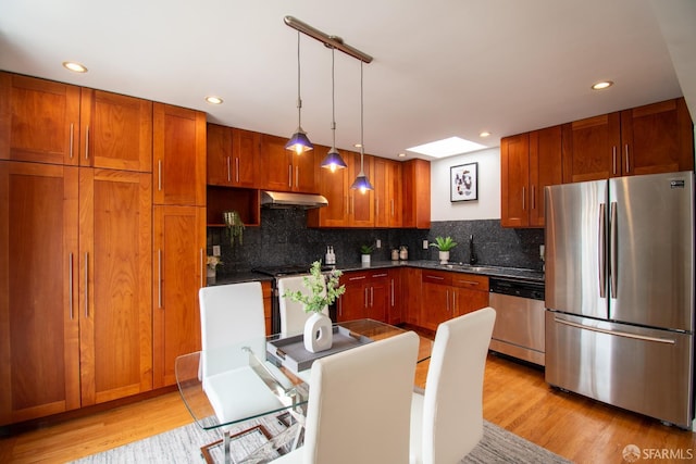 1579 46th Ave, San Francisco, CA 94122 - kitchen with appliances with stainless steel finishes, under cabinet range hood, light wood-style floors, decorative backsplash, and recessed lighting