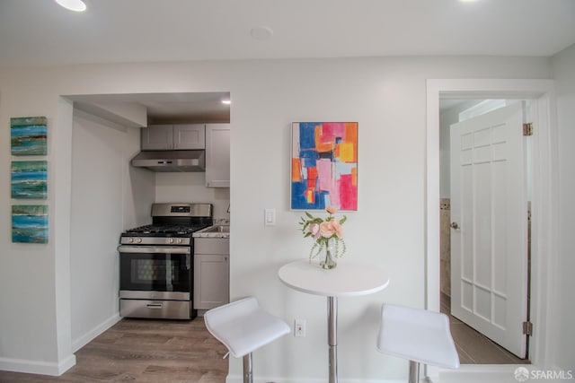 1579 46th Ave, San Francisco, CA 94122 - kitchen featuring gas stove, under cabinet range hood, wood finished floors, and gray cabinetry