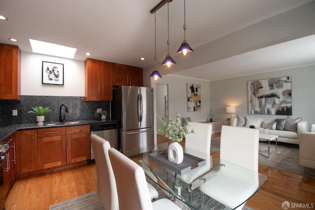 1579 46th Ave, San Francisco, CA 94122 - kitchen with stainless steel appliances, dark countertops, decorative light fixtures, decorative backsplash, and a skylight