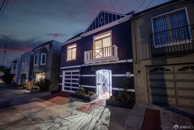 1579 46th Ave, San Francisco, CA 94122 - view of front of property with a balcony, an attached garage, stucco siding, and driveway