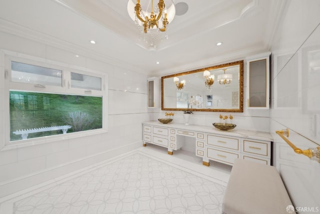 full bath featuring a chandelier, ornamental molding, double vanity, a raised ceiling, and recessed lighting