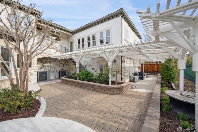 view of patio / terrace featuring a pergola, central AC, stairway, and fence