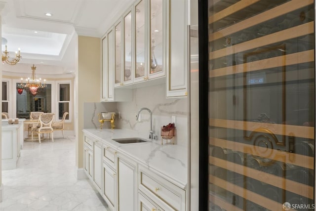 bar area featuring a sink, a chandelier, beverage cooler, recessed lighting, and a tray ceiling