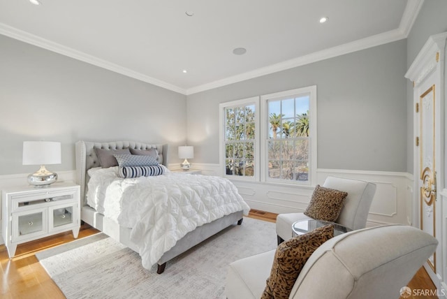 bedroom with light wood-style flooring, wainscoting, crown molding, and recessed lighting