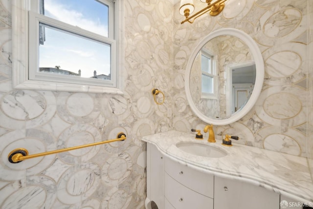 bathroom with vanity, healthy amount of natural light, and wallpapered walls