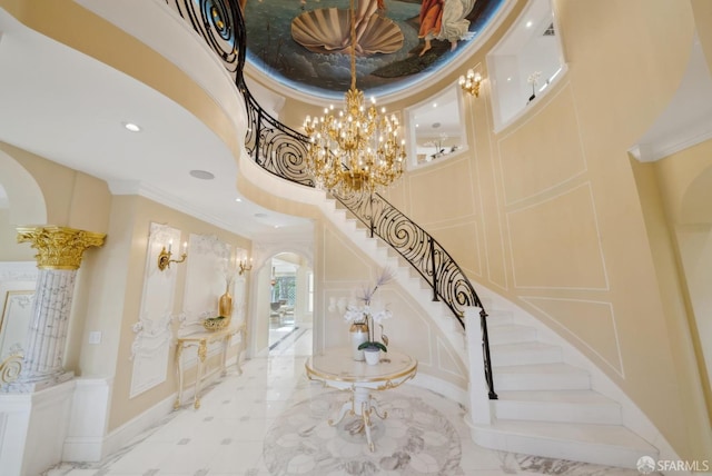 stairs featuring arched walkways, a high ceiling, a decorative wall, ornamental molding, and recessed lighting