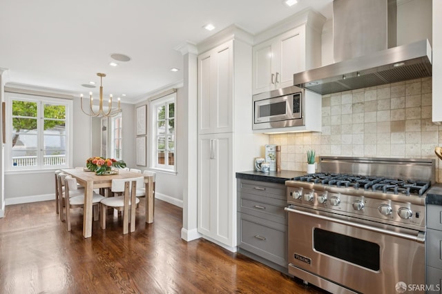 1983 15th Ave, San Francisco, CA 94116 - kitchen with appliances with stainless steel finishes, wall chimney range hood, dark countertops, a chandelier, and tasteful backsplash