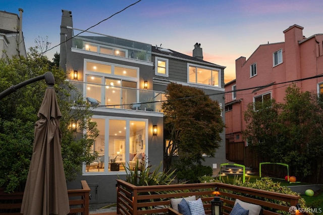 1983 15th Ave, San Francisco, CA 94116 - back of house at dusk with a chimney, a balcony, and stucco siding
