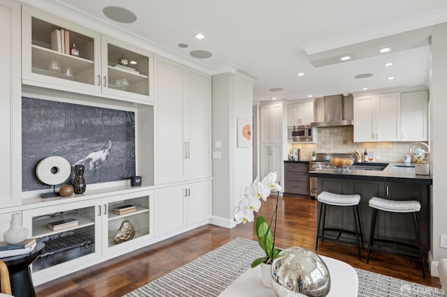 1983 15th Ave, San Francisco, CA 94116 - kitchen featuring wall chimney exhaust hood, stainless steel microwave, white cabinets, a kitchen bar, and glass insert cabinets