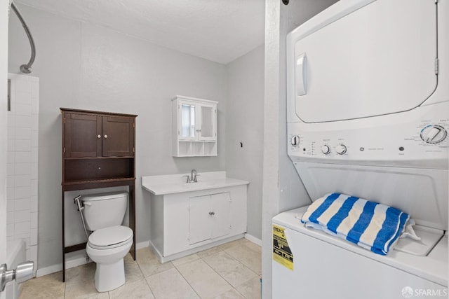 laundry room featuring stacked washer and clothes dryer, sink, and light tile patterned floors