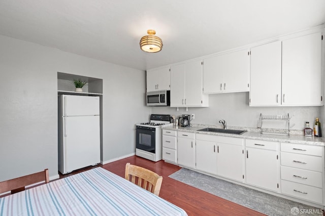 kitchen with dark wood-type flooring, white appliances, sink, and white cabinets