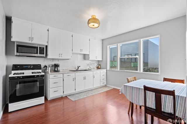 kitchen with white cabinetry, sink, range with gas stovetop, and dark hardwood / wood-style floors