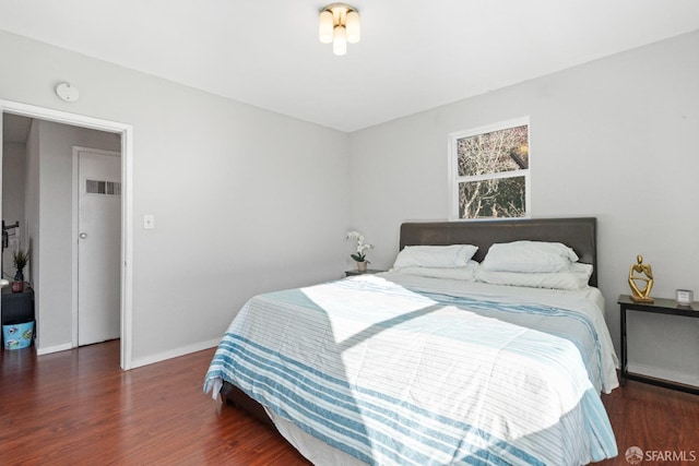 bedroom with dark hardwood / wood-style flooring