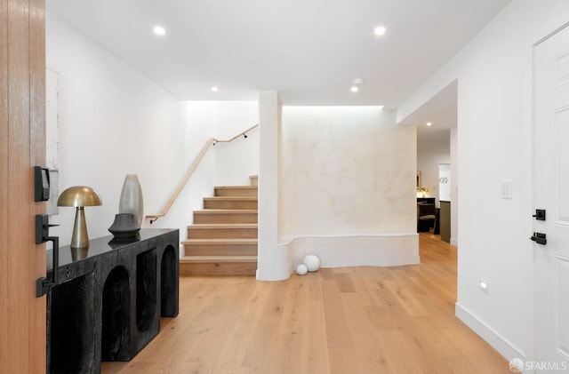 hall with recessed lighting, stairway, baseboards, and wood finished floors