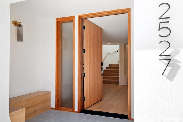 hall with tile patterned flooring and stairway