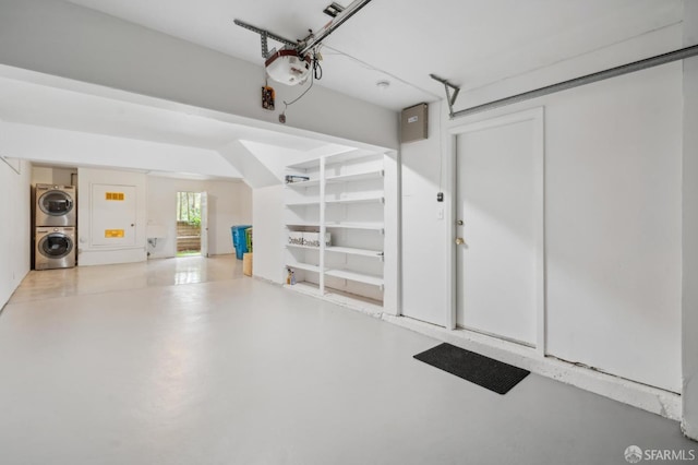 garage featuring stacked washer and dryer and a garage door opener