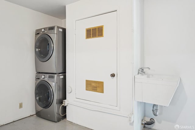 laundry area featuring stacked washer / dryer, laundry area, visible vents, and a sink