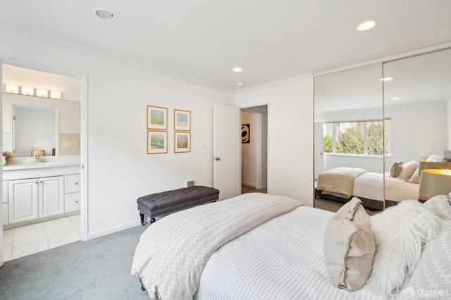 bedroom featuring crown molding, a closet, light carpet, and a sink