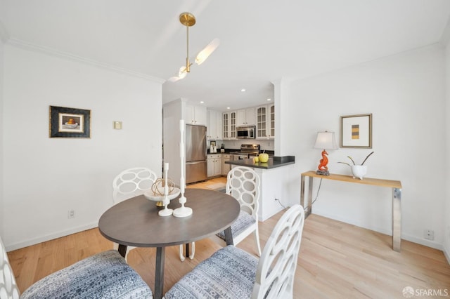 dining room featuring crown molding, recessed lighting, light wood-style flooring, and baseboards