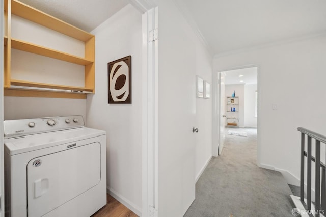 clothes washing area featuring crown molding, light colored carpet, washer / dryer, laundry area, and baseboards