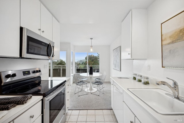 kitchen with white cabinetry, hanging light fixtures, light colored carpet, and stainless steel appliances