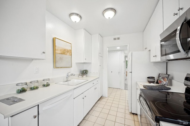 kitchen featuring light tile patterned flooring, stainless steel appliances, white cabinetry, and sink