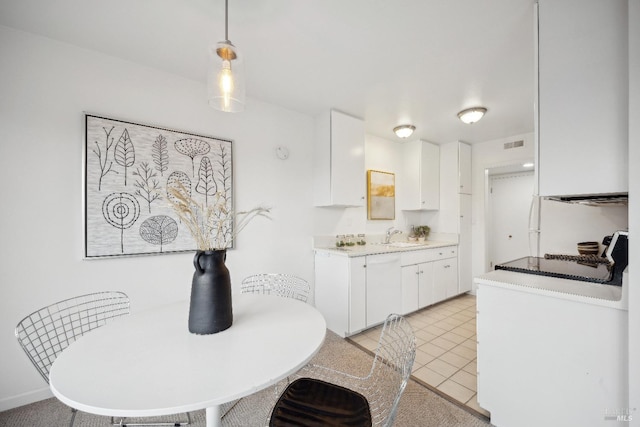 kitchen featuring white cabinetry, sink, stove, decorative light fixtures, and light tile patterned floors