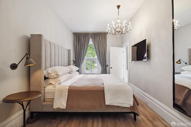 bedroom featuring a notable chandelier, wood-type flooring, and vaulted ceiling