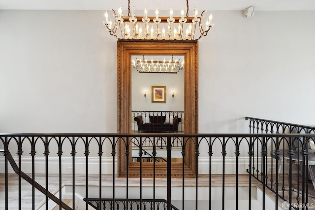 staircase featuring hardwood / wood-style floors and a chandelier