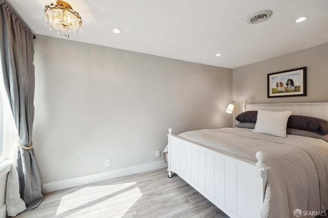 bedroom with light wood-type flooring and a chandelier