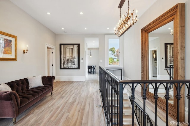 hallway with a notable chandelier and light hardwood / wood-style flooring