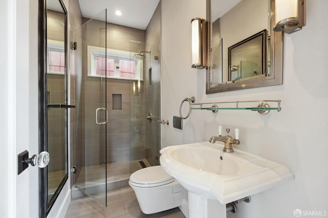 bathroom featuring toilet and an enclosed shower