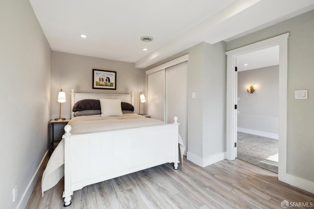 bedroom with light wood-type flooring and a closet