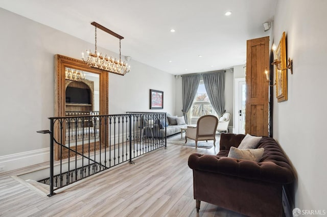 living room with light hardwood / wood-style flooring and a chandelier