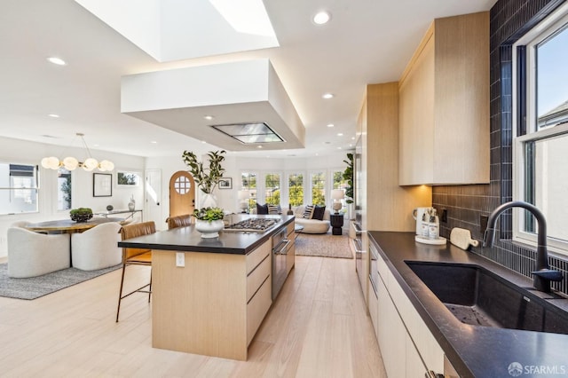 kitchen with dark countertops, modern cabinets, open floor plan, and a sink