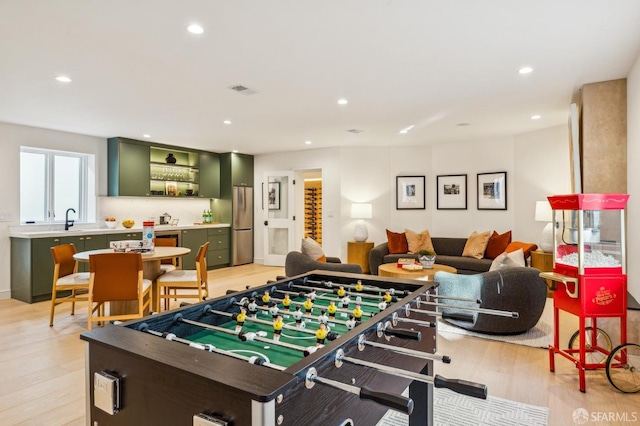 playroom featuring light wood-style floors, recessed lighting, visible vents, and a sink