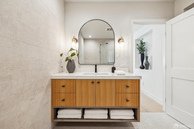 bathroom with visible vents, walk in shower, and vanity