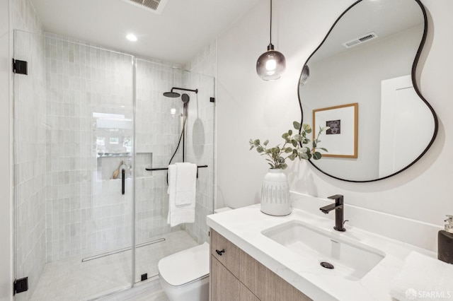 bathroom featuring visible vents, vanity, a shower stall, and toilet