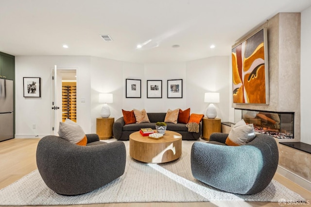 living area with light wood-style floors, recessed lighting, a fireplace, and baseboards