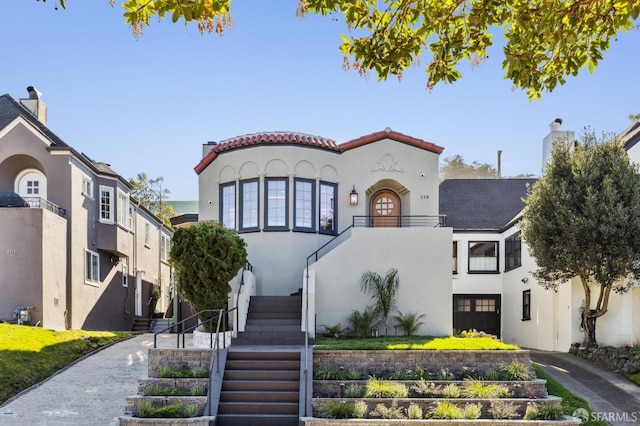 mediterranean / spanish-style house featuring stairs and stucco siding