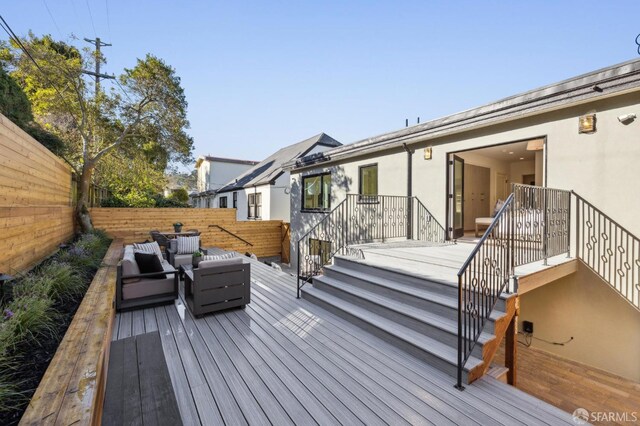 wooden terrace with stairway, outdoor lounge area, and fence private yard