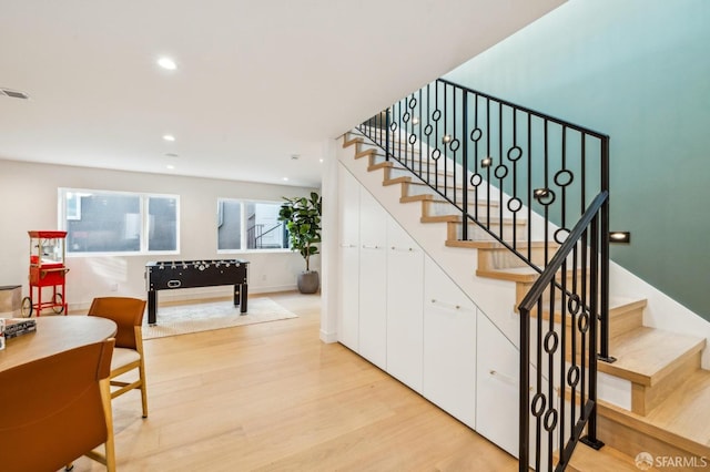 stairway featuring recessed lighting, visible vents, baseboards, and wood finished floors