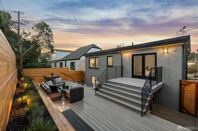 back of property featuring a deck, fence, an outdoor living space, and stucco siding